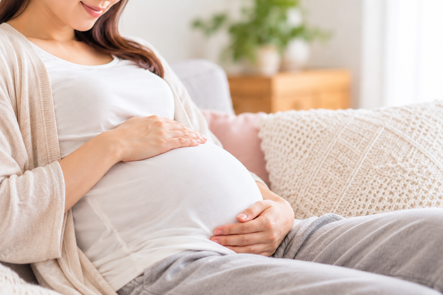 お腹を優しく抱える妊婦さん
