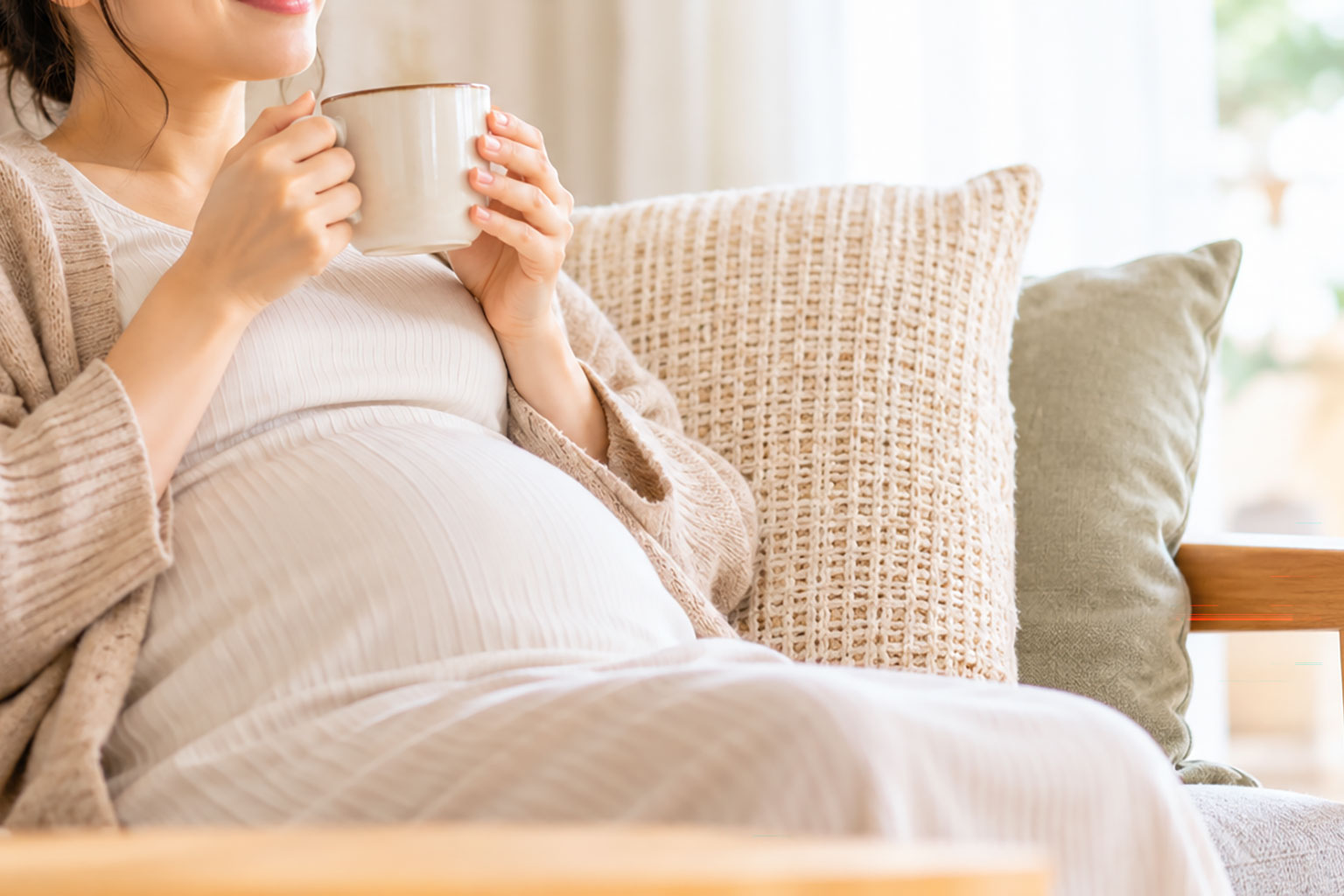 温かい飲み物を飲んで身体を温める妊婦さん